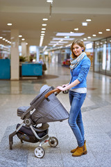 Fototapeta na wymiar Young woman with baby carriage