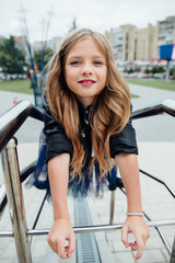 Obraz premium Urban fashion portrait of a teenage girl in the street at the railing on the stairs.