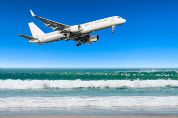 Fototapeta na wymiar Passenger aircraft approaches the landing at the airport low over ocean sand beach.