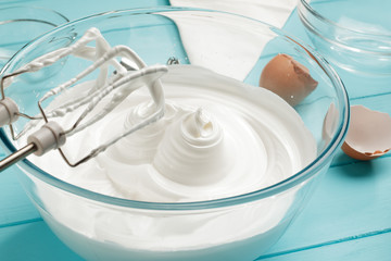 Whipped cream in glass bowl with whisks on blue wooden table. - 192371787