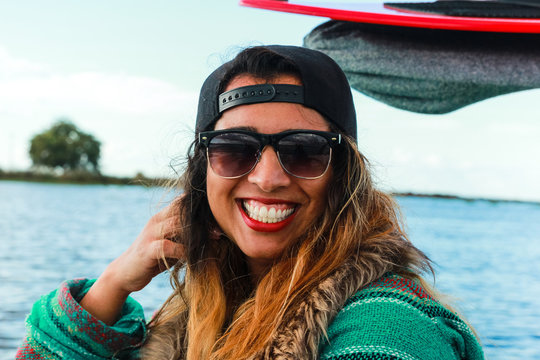 Mixed race happy young woman smiles and poses on a boat during a day on the lake