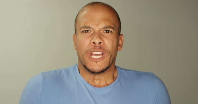 4K Close up portrait man staring into camera lens, shouting with mouth wide open. Slow motion.