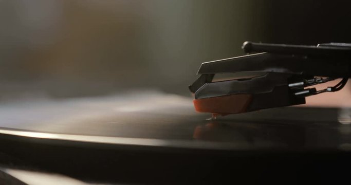Close-up of using an antiquarian vinyl record player. turntable player,dropping stylus needle on vinyl record playing