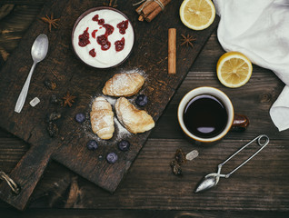 Obraz na płótnie Canvas a cup of black tea, and yogurt with raspberry jam