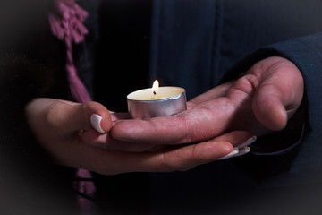 hands of Bridal couple with wedding rings and the candle