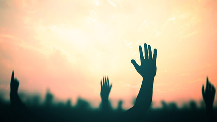 Easter Religious concept: Silhouette many people raised hands over autumn sunset background