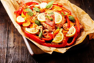 Lachsfilet auf backpapier mit gemüse