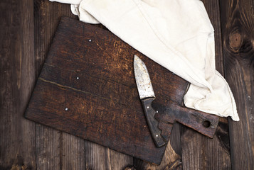 empty old brown wooden kitchen cutting board with a knife