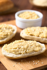 Chickpea spread or hummus on bread sprinkled with sesame seeds, photographed with natural light (Selective Focus, Focus one third into the image)