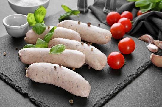 Delicious white sausages on slate plate