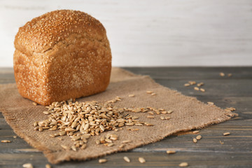 Scattered sunflower seeds and fresh bread on wooden table