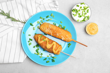 Tasty corn dogs with mustard on plate