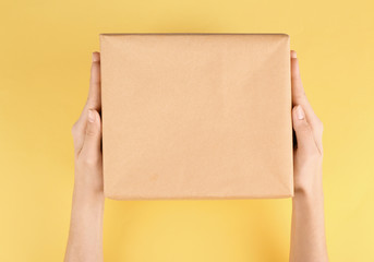 Woman holding parcel on color background