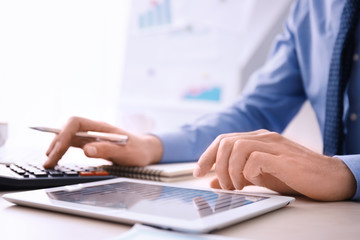 Man working at table in office, closeup. Financial trading concept