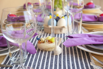 Decorative ceramic rabbit and nest with colorful eggs for Easter table setting