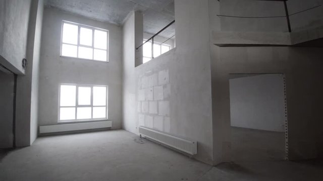 Finishing works at renovated apartment. Clip. Plastered walls, wallpapering, painted ceiling, leveled floor. Electrical wiring installation. Empty light interior. Apartment renovation.
