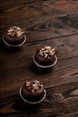 chocolate cupcakes on a brown wooden background decorated with chocolate shaving