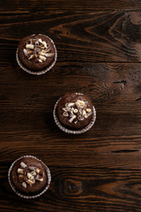 chocolate cupcakes on a brown wooden background decorated with chocolate shaving