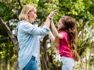 Mother and daughter having fun together in a park. Family and lifestyle concept