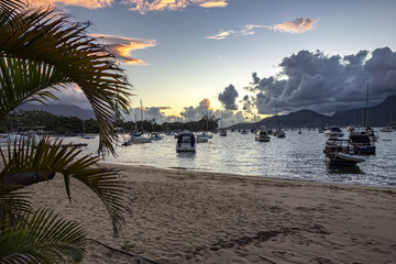Ilhabela beach Saco da capela with boats and sailboats in the sea at sunset - Sao Paulo, Brazil