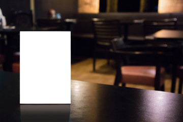 Mockup white label menu frame on table with cafe restaurant interior background