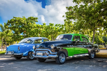 Zwei amerikanische Oldtimer parken unter blauem Himmel in Varadero Kuba - HDR - Serie Cuba Reportage 