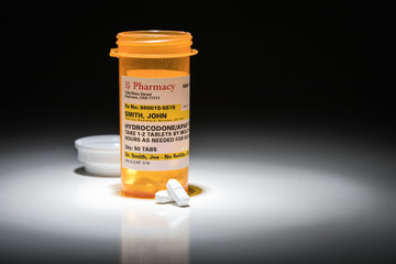 Hydrocodone Pills and Prescription Bottles with Non Proprietary Label. No model release required - contains ficticious information.