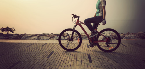 Obraz premium cyclist riding bike on the sunrise coast path