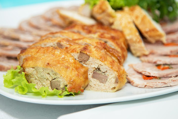 Tasty meat rolls and sliced bacon on white plate