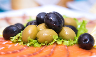 Olives and sliced salmon. Appetizer on italian restaurant.