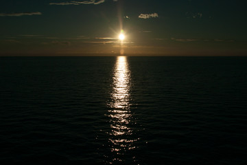 Sunset on the ocean with the sunlight reflecting in the ocean, already dark.