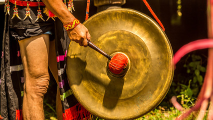 Dayak (native tribe of Borneo) man hitting the Gong on traditional ceremony