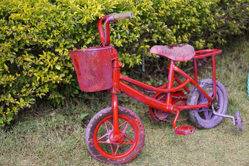 Fototapeta na wymiar Old red bicycle in playground