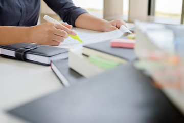 Education concept. Students studying and brainstorming campus concept. Close up of students discussing their subject on books textbooks and writing to notebook. Selective focus.