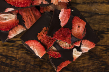Stack of chocolate slices with strawberry on wooden background