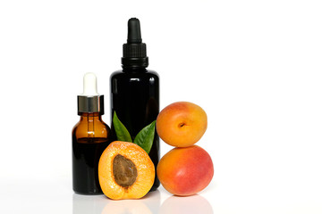 apricot oil .organic natural apricot oil in glass  brown bottles and fresh apricot fruits on a white background with reflection. 