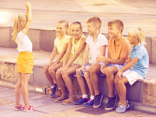 cheerful kids playing charades outdoors