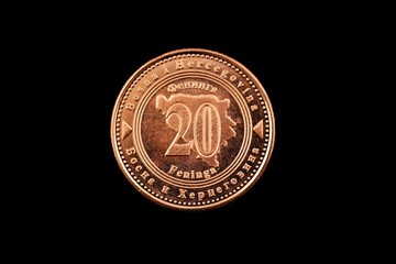 A macro image of a Bosnian 20 fenings coin isolated on a black background