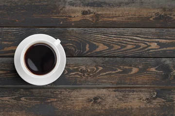 Selbstklebende Fototapeten Black coffee cup on dark wooden table top view © Andrey Kuzmin