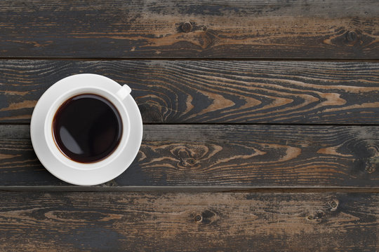 Black coffee cup on dark wooden table top view