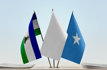 Flags of Lesotho and Somalia with a white flag in the middle