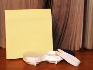 contact lenses in case and yellow paper