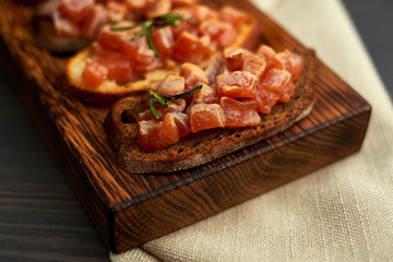 bruschetta with delicious fish on a cream cushion with capers and olive oil