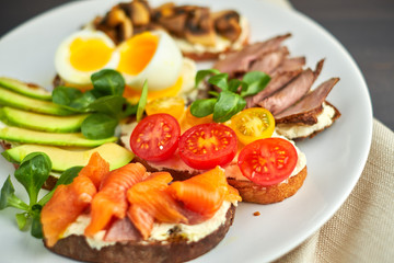 Bruschetta, assorted, different fillings, on plates with a soft-boiled egg in the middle