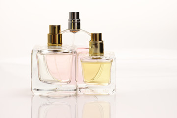 Three pastel colored perfume bottles