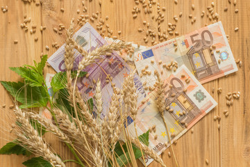wheat and cash money on the wooden background