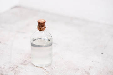 Bottle with coconut oil on gray concrete background. Body and skincare spa beauty essentials, after sun skin remedy treatment. Copyspace. Beauty blogging minimalism concept