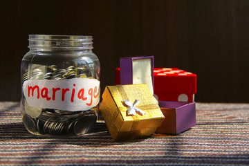 Coins in money jar with marriage label, - obrazy, fototapety, plakaty