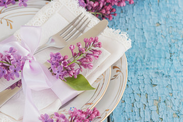 Tableware and silverware with bouquet of light violet lilac