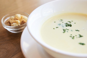 Delicious cheese soup. White dishes. Small crackers